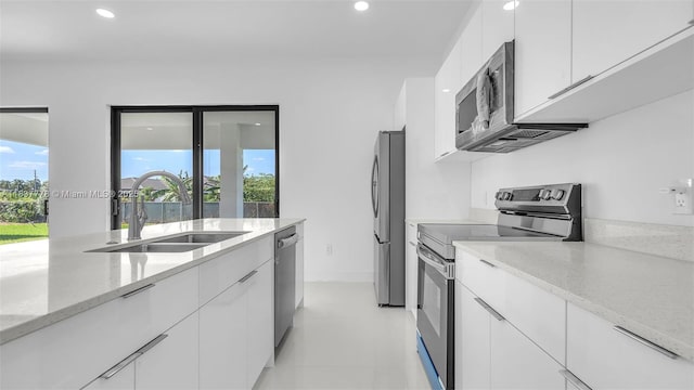 23120 SW 154th Ct, Miami, FL 33170 - kitchen with appliances with stainless steel finishes, white cabinetry, recessed lighting, light stone countertops, and modern cabinets