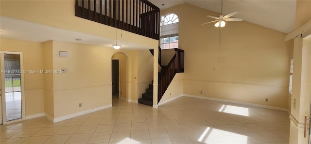 2957 Oak Park Cir, Davie, FL 33328 - unfurnished living room featuring arched walkways, high vaulted ceiling, stairs, ceiling fan, and tile patterned floors