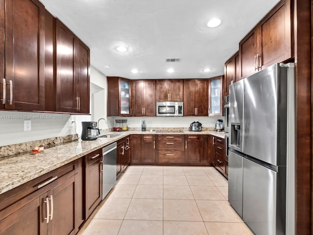 321 NW 93rd Ave, Pembroke Pines, FL 33024 - kitchen featuring appliances with stainless steel finishes, light tile patterned floors, glass insert cabinets, light stone counters, and recessed lighting