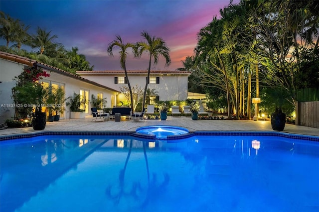 607 Melaleuca Ln, Miami, FL 33137 - pool at dusk with a pool with connected hot tub and a patio area