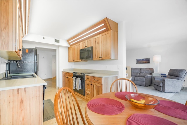 1201 S Ocean Dr Unit 410S, Hollywood, FL 33019 - kitchen with black appliances, light countertops, light brown cabinets, and light tile patterned flooring