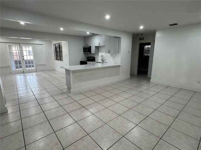 2855 SW 10th St, Fort Lauderdale, FL 33312 - kitchen with light countertops, light tile patterned flooring, recessed lighting, open floor plan, and range
