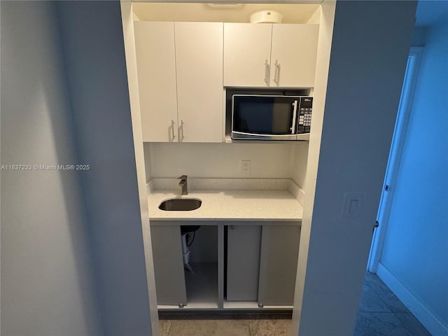 2855 SW 10th St, Fort Lauderdale, FL 33312 - kitchen featuring stainless steel microwave, light countertops, and white cabinets