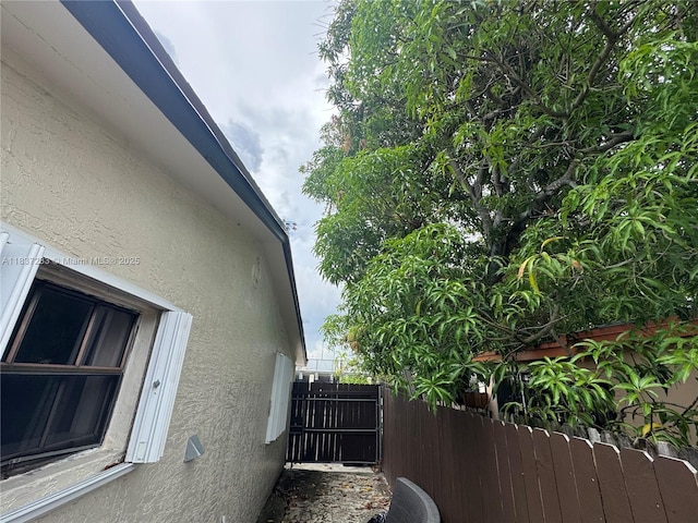 2855 SW 10th St, Fort Lauderdale, FL 33312 - view of side of home featuring stucco siding and a gate
