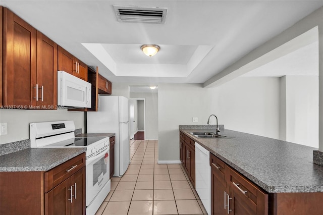 5640 NW 13th Ct, Lauderhill, FL 33313 - kitchen with white appliances, light tile patterned flooring, a raised ceiling, a peninsula, and dark countertops