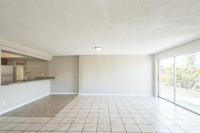 5640 NW 13th Ct, Lauderhill, FL 33313 - unfurnished living room with a textured ceiling and tile patterned flooring