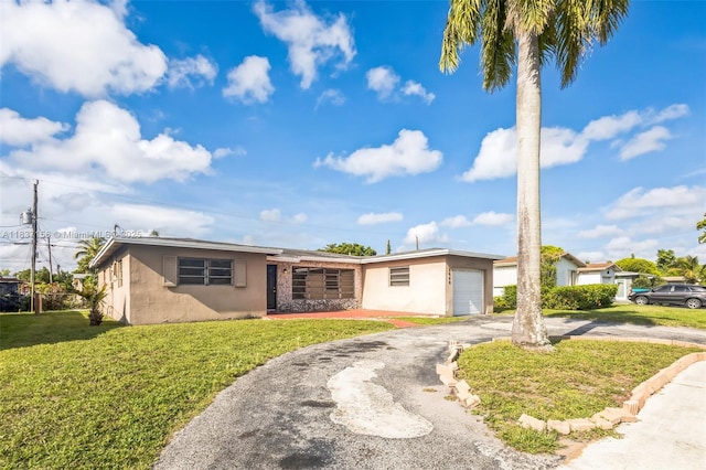 5640 NW 13th Ct, Lauderhill, FL 33313 - view of front of house with stucco siding, an attached garage, driveway, and a front yard