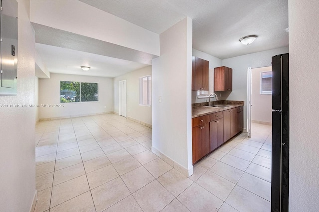 312 SW 2nd Ter, Hallandale Beach, FL 33009 - kitchen featuring light tile patterned flooring, brown cabinetry, freestanding refrigerator, and open floor plan