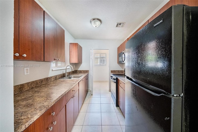 312 SW 2nd Ter, Hallandale Beach, FL 33009 - kitchen featuring black appliances, light tile patterned floors, and brown cabinetry