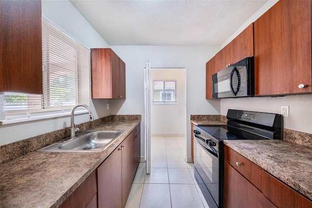312 SW 2nd Ter, Hallandale Beach, FL 33009 - kitchen featuring black appliances, light tile patterned floors, brown cabinetry, a textured ceiling, and dark countertops