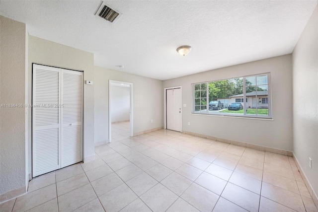312 SW 2nd Ter, Hallandale Beach, FL 33009 - unfurnished bedroom featuring a textured ceiling and light tile patterned floors