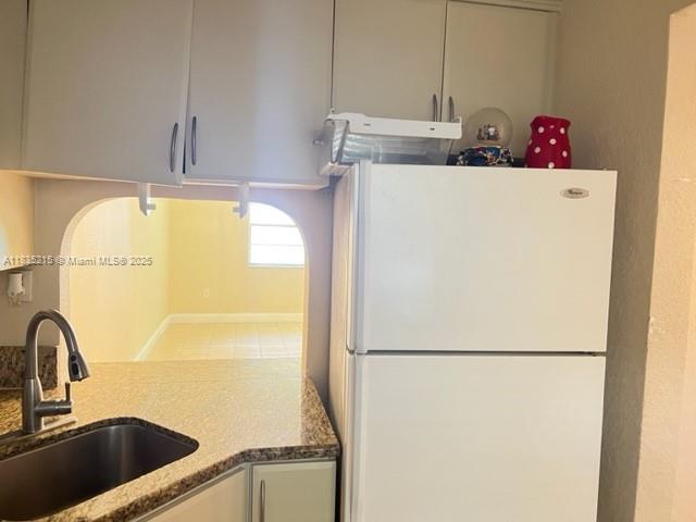 17255 SW 95th Ave Unit 202, Palmetto Bay, FL 33157 - kitchen featuring freestanding refrigerator and light stone counters
