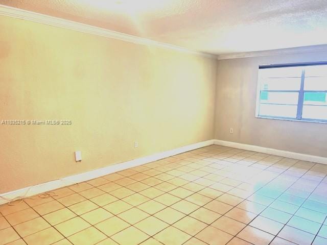 17255 SW 95th Ave Unit 202, Palmetto Bay, FL 33157 - empty room with ornamental molding, light tile patterned flooring, and a textured ceiling