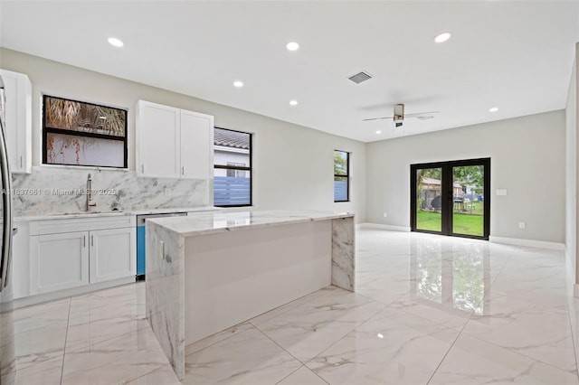 1244 NW 30th Ave, Fort Lauderdale, FL 33311 - kitchen with light marble finish floors, dishwasher, recessed lighting, white cabinetry, and backsplash