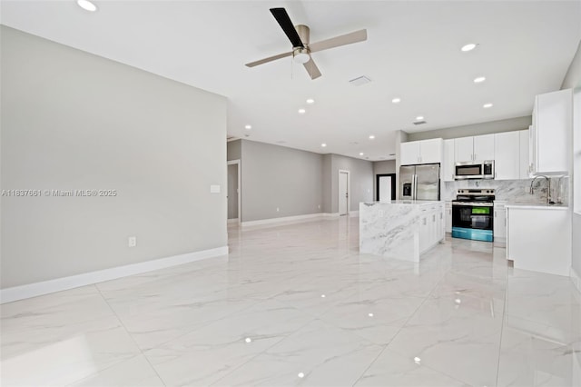 1244 NW 30th Ave, Fort Lauderdale, FL 33311 - kitchen featuring appliances with stainless steel finishes, a kitchen island, light marble finish flooring, open floor plan, and recessed lighting