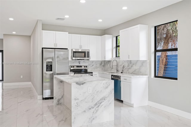 1244 NW 30th Ave, Fort Lauderdale, FL 33311 - kitchen featuring stainless steel appliances, light stone countertops, backsplash, light marble finish flooring, and recessed lighting