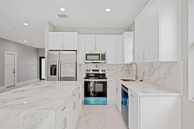 1244 NW 30th Ave, Fort Lauderdale, FL 33311 - kitchen featuring stainless steel appliances, light stone counters, light marble finish floors, white cabinets, and recessed lighting