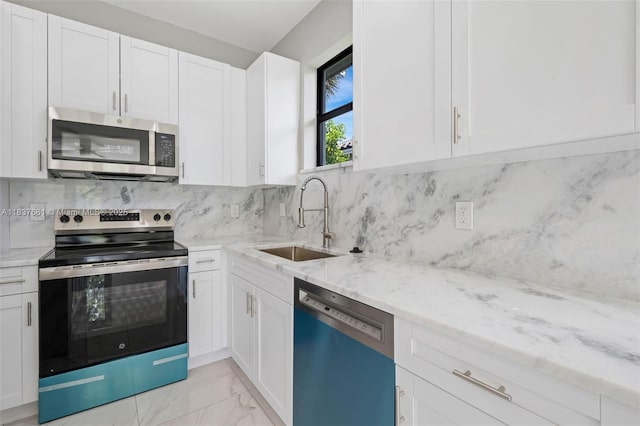 1244 NW 30th Ave, Fort Lauderdale, FL 33311 - kitchen featuring stainless steel appliances, light stone countertops, light marble finish floors, white cabinetry, and decorative backsplash
