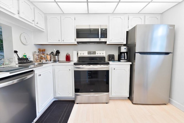 1501 S Ocean Blvd Unit 227, Lauderdale By The Sea, FL 33062 - kitchen with stainless steel appliances, white cabinetry, light countertops, a drop ceiling, and light wood-style floors