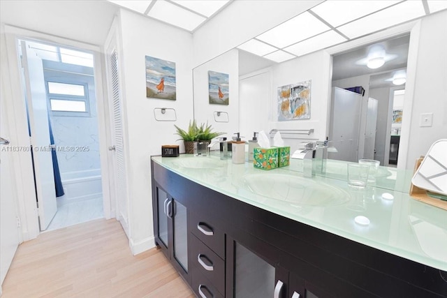 1501 S Ocean Blvd Unit 227, Lauderdale By The Sea, FL 33062 - bathroom featuring double vanity, wood finished floors, and bathing tub / shower combination