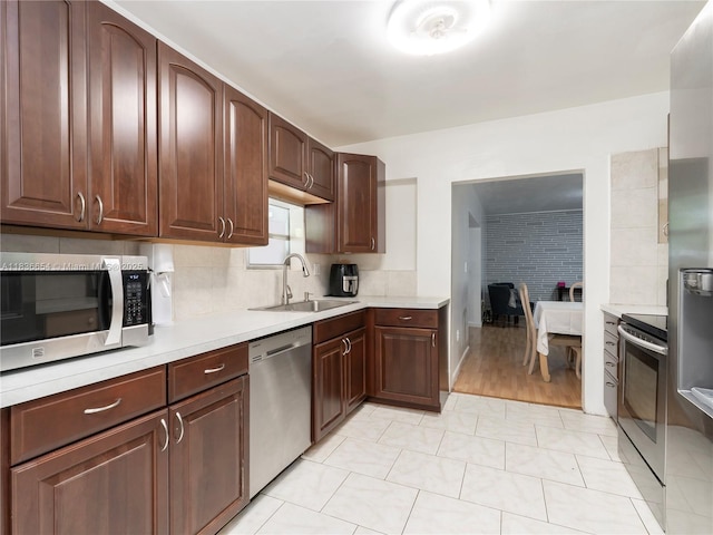 6530 Tyler St, Hollywood, FL 33024 - kitchen with stainless steel appliances, light countertops, backsplash, and dark brown cabinetry