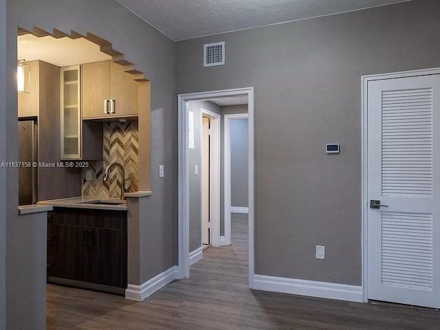 1611 Euclid Ave Unit 5, Miami Beach, FL 33139 - kitchen featuring light countertops, dark wood-style floors, tasteful backsplash, and glass insert cabinets