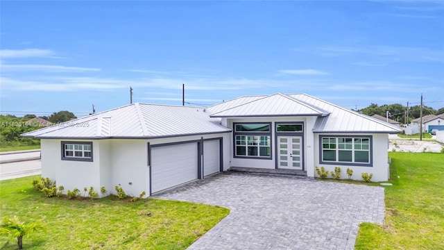 121 SW Sea Lion Rd, Port St Lucie, FL 34953 - view of front of home featuring a garage, a standing seam roof, stucco siding, a front yard, and a metal roof