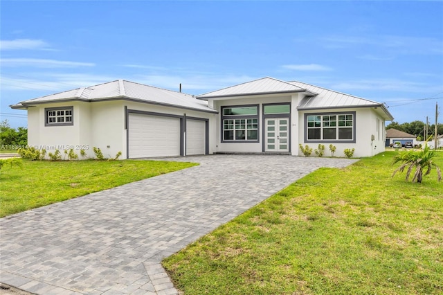 121 SW Sea Lion Rd, Port St Lucie, FL 34953 - view of front of home with an attached garage, stucco siding, and a front lawn
