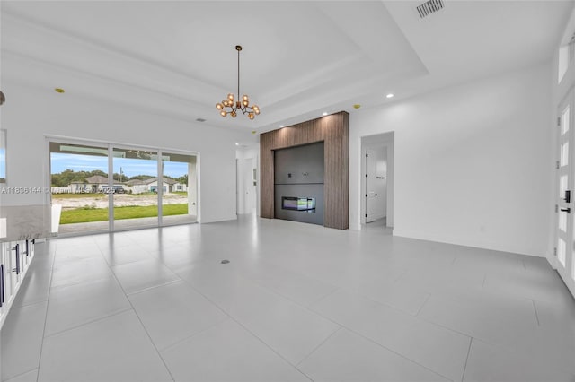 121 SW Sea Lion Rd, Port St Lucie, FL 34953 - unfurnished living room featuring a chandelier, a tray ceiling, and recessed lighting