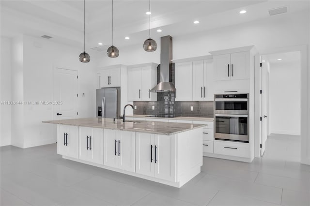 121 SW Sea Lion Rd, Port St Lucie, FL 34953 - kitchen with appliances with stainless steel finishes, wall chimney exhaust hood, a large island with sink, tasteful backsplash, and light tile patterned floors