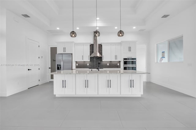 121 SW Sea Lion Rd, Port St Lucie, FL 34953 - kitchen with a tray ceiling, wall chimney exhaust hood, appliances with stainless steel finishes, recessed lighting, and decorative backsplash