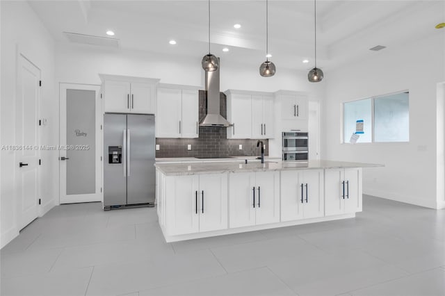 121 SW Sea Lion Rd, Port St Lucie, FL 34953 - kitchen featuring appliances with stainless steel finishes, wall chimney exhaust hood, decorative backsplash, white cabinetry, and recessed lighting