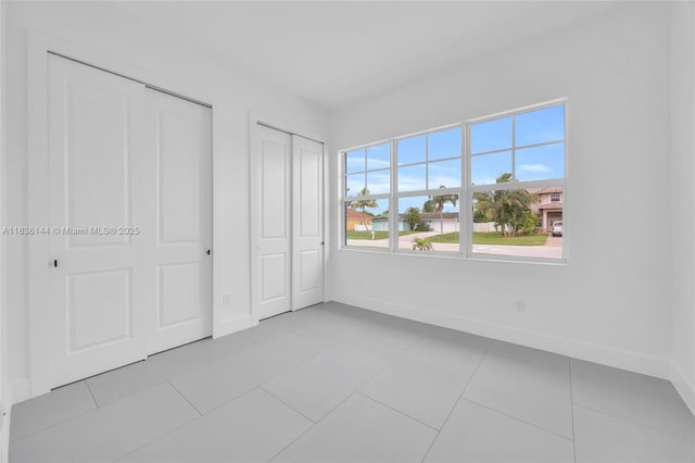 121 SW Sea Lion Rd, Port St Lucie, FL 34953 - unfurnished bedroom with two closets and light tile patterned floors