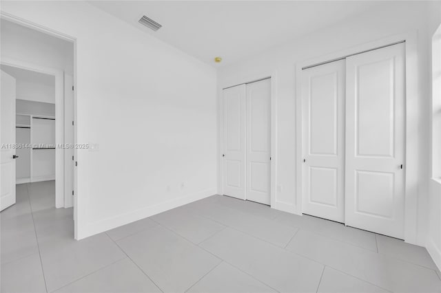 121 SW Sea Lion Rd, Port St Lucie, FL 34953 - unfurnished bedroom with multiple closets and tile patterned floors