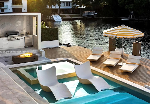 2225 NE 19th St, Fort Lauderdale, FL 33305 - dock area with exterior kitchen, an outdoor fire pit, a deck with water view, and a pool with connected hot tub