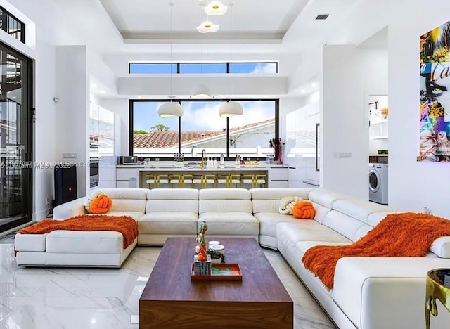 2225 NE 19th St, Fort Lauderdale, FL 33305 - living room featuring washer / dryer, marble finish floors, and a raised ceiling