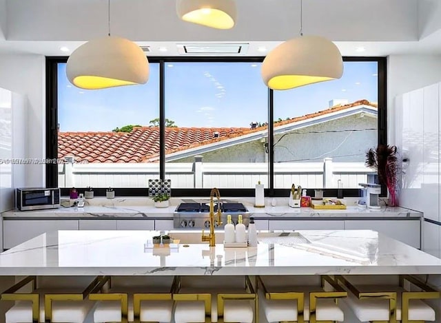 2225 NE 19th St, Fort Lauderdale, FL 33305 - kitchen with hanging light fixtures, light stone counters, and appliances with stainless steel finishes