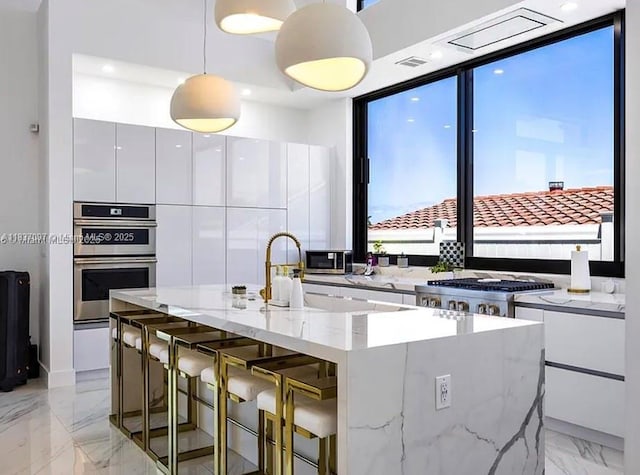 2225 NE 19th St, Fort Lauderdale, FL 33305 - kitchen featuring modern cabinets, appliances with stainless steel finishes, white cabinetry, and light marble finish floors