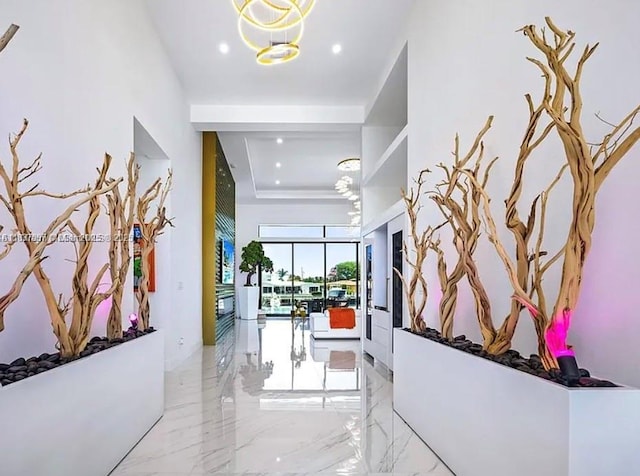2225 NE 19th St, Fort Lauderdale, FL 33305 - corridor with recessed lighting, marble tiled floors, a raised ceiling, and a chandelier