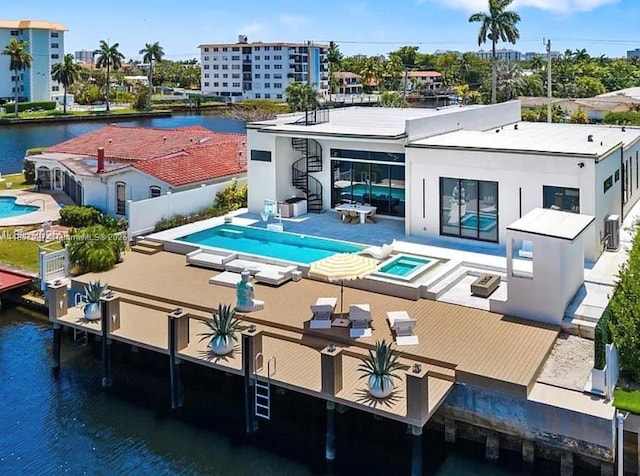 2225 NE 19th St, Fort Lauderdale, FL 33305 - rear view of house with an outdoor pool, stairway, stucco siding, and a water view