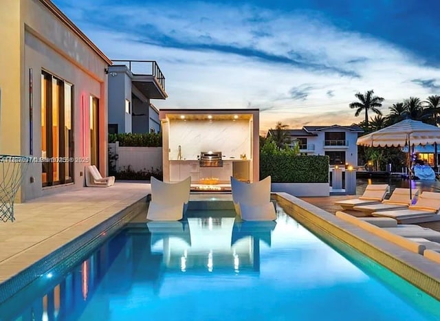 2225 NE 19th St, Fort Lauderdale, FL 33305 - pool at dusk with exterior kitchen and a patio area
