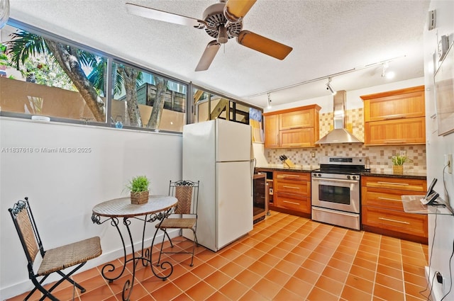 2778 Day Ave Unit 2, Miami, FL 33133 - kitchen with stainless steel range oven, freestanding refrigerator, wall chimney exhaust hood, ceiling fan, and backsplash