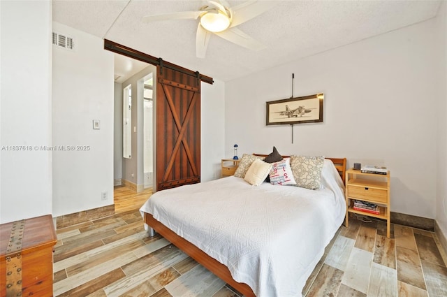2778 Day Ave Unit 2, Miami, FL 33133 - bedroom featuring a barn door, wood finished floors, a textured ceiling, and a ceiling fan