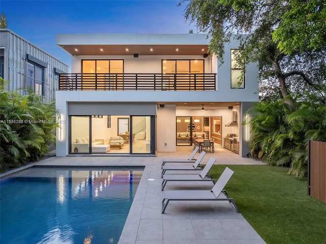 260 NW 47th St, Miami, FL 33127 - back of house with a balcony, stucco siding, a lawn, a patio area, and a ceiling fan