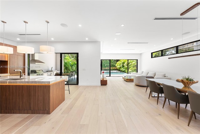 260 NW 47th St, Miami, FL 33127 - kitchen featuring modern cabinets, wall chimney range hood, range, recessed lighting, and light wood-style flooring