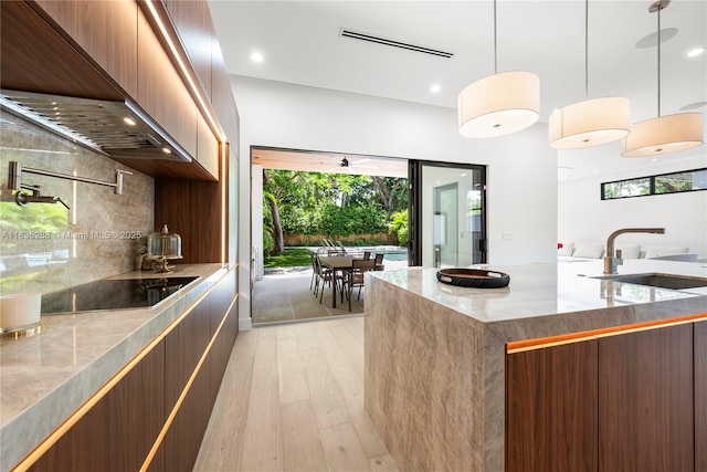 260 NW 47th St, Miami, FL 33127 - kitchen with black electric stovetop, modern cabinets, light wood-type flooring, and recessed lighting