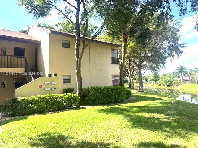 3817 Cocoplum Cir Unit 3585, Coconut Creek, FL 33063 - view of home's exterior featuring a lawn and stucco siding