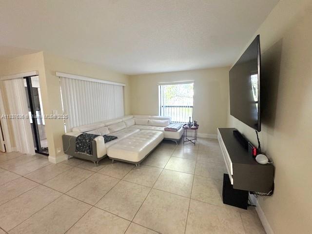 3817 Cocoplum Cir Unit 3585, Coconut Creek, FL 33063 - living room with light tile patterned flooring and baseboards