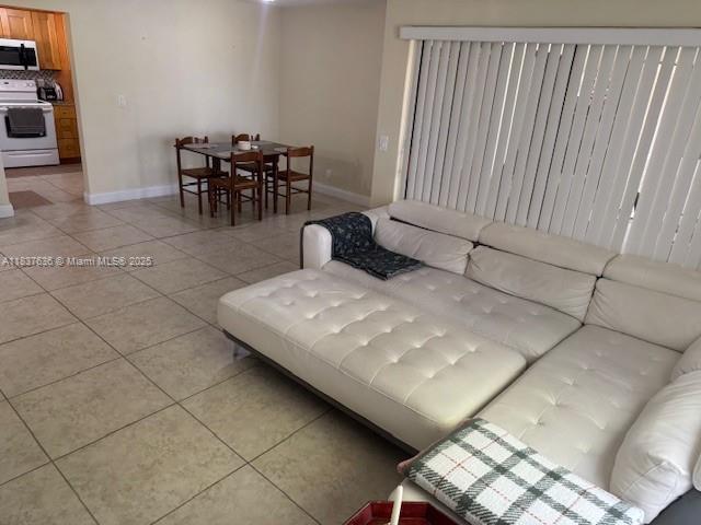 3817 Cocoplum Cir Unit 3585, Coconut Creek, FL 33063 - living room featuring light tile patterned flooring and baseboards