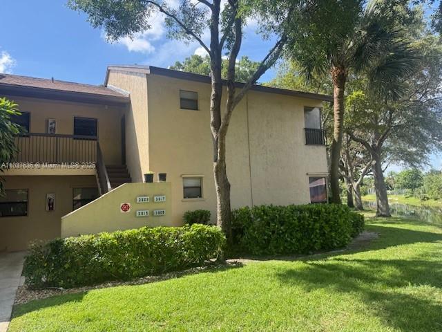 3817 Cocoplum Cir Unit 3585, Coconut Creek, FL 33063 - view of home's exterior featuring stucco siding and a yard